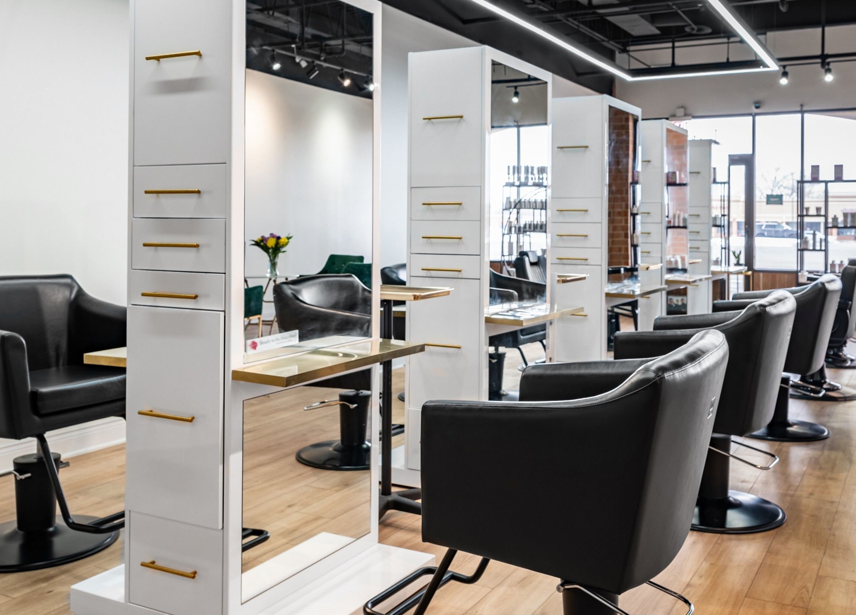 Elegant salon interior at Artisan Theory Salon, Villa Park, Illinois, US featuring modern black chairs and mirrors.