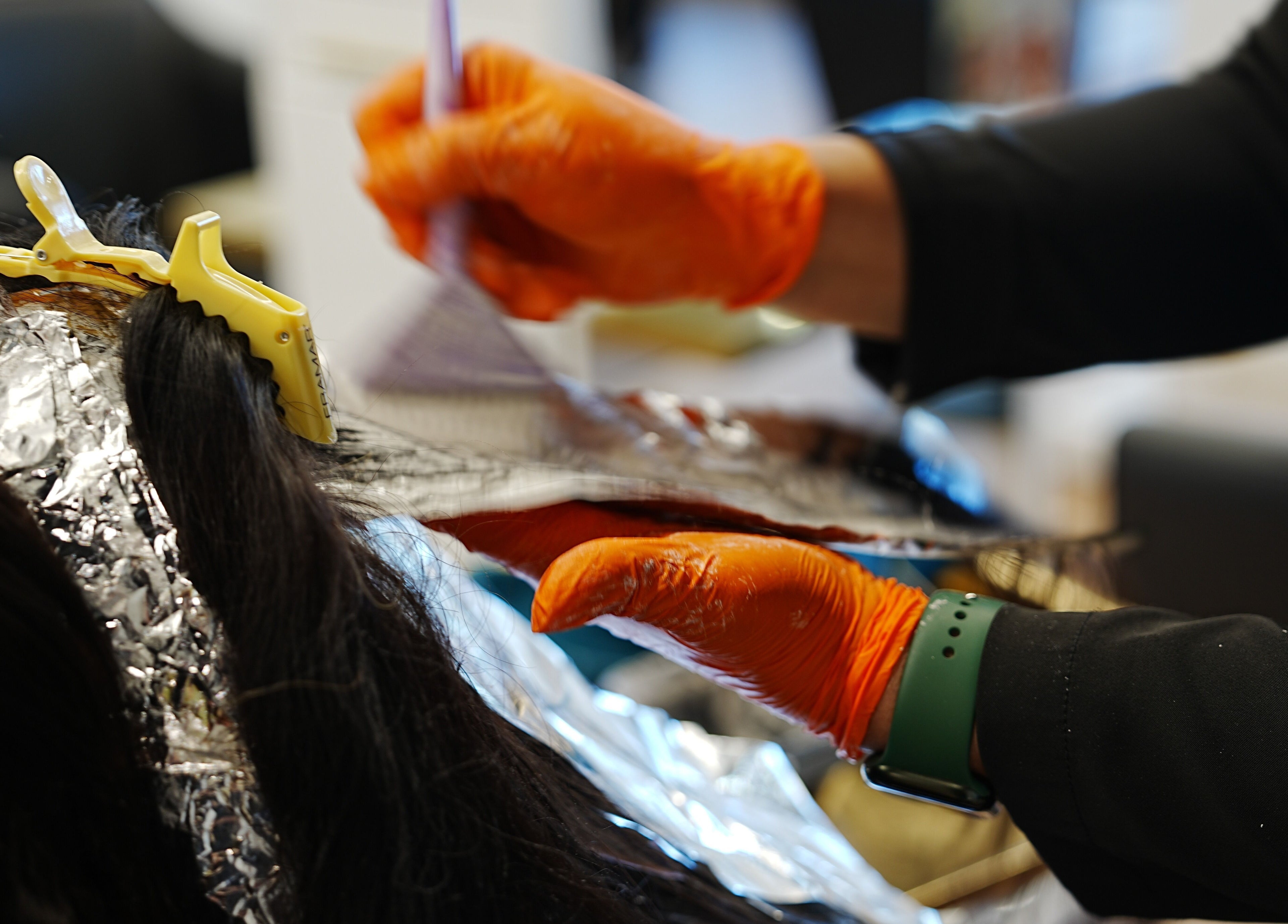 Hair coloring in progress at Artisan Theory Salon, Villa Park, Illinois, US with vibrant stylists at work.