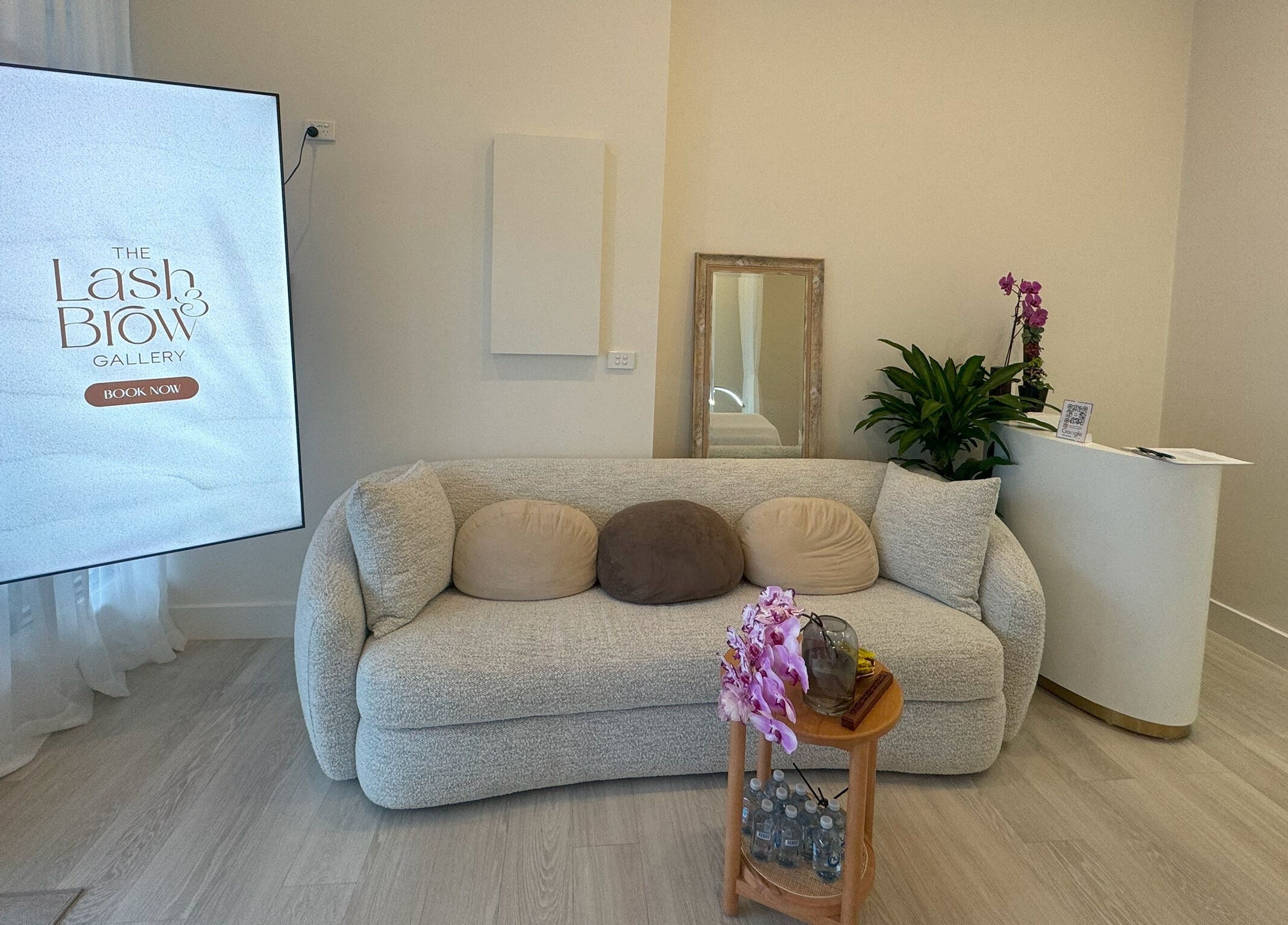 Elegant waiting area at The Lash And Brow Gallery Malvern, Melbourne, Victoria, AU with cozy sofa and plants.