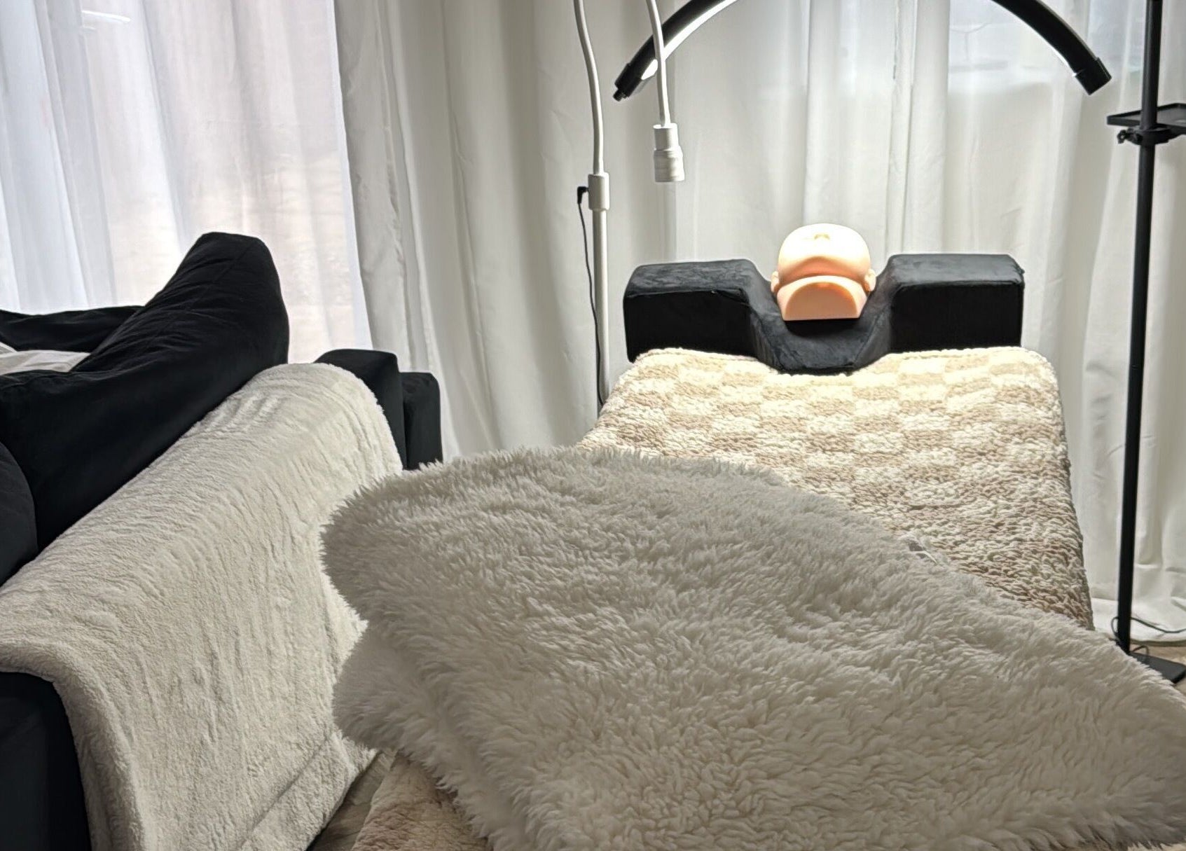 Cozy treatment area at Lusso Lashes, Brockworth, England, GB, featuring padded bed and warm lighting.