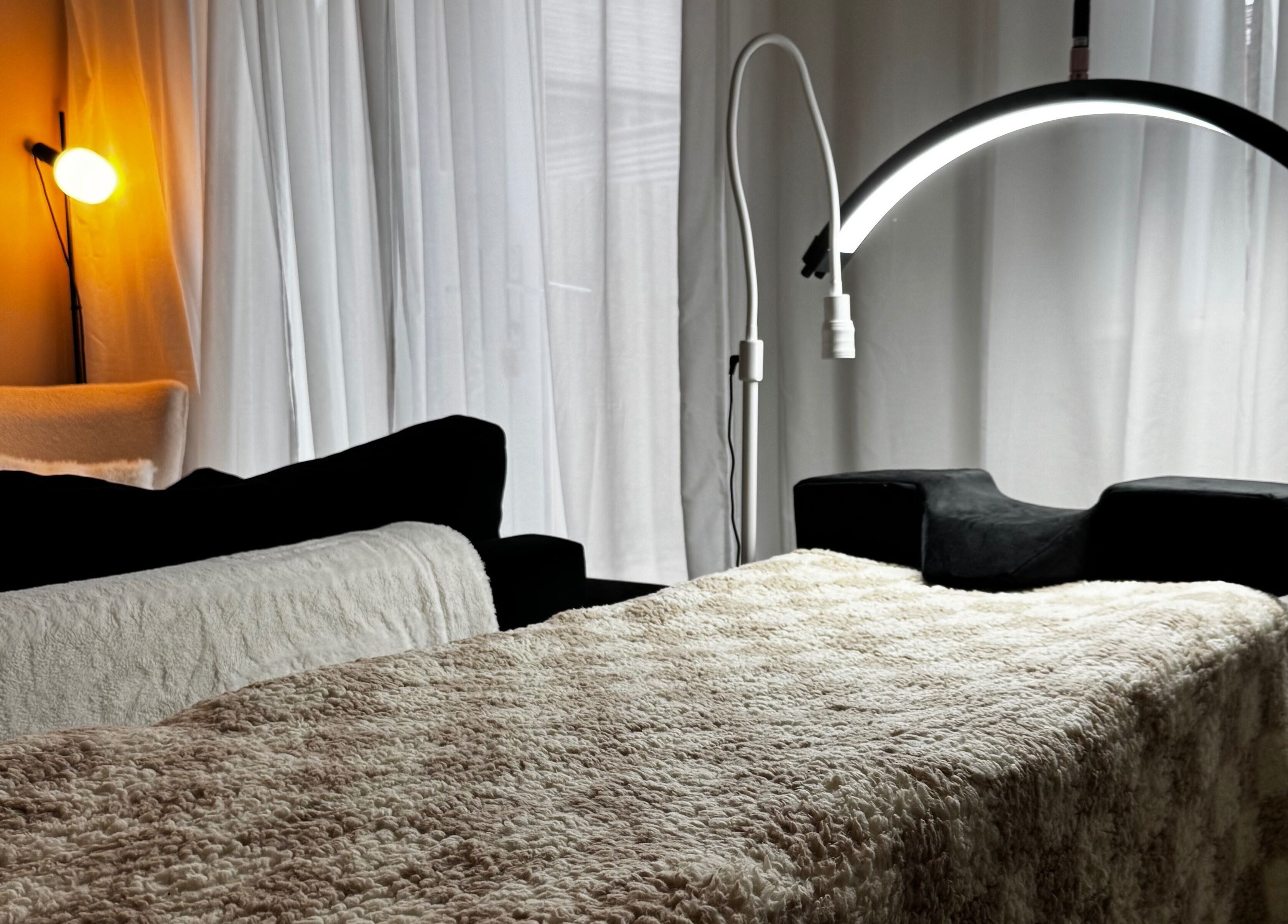 Welcoming treatment room at Lusso Lashes, Brockworth, England, GB with comfortable lighting and decor.