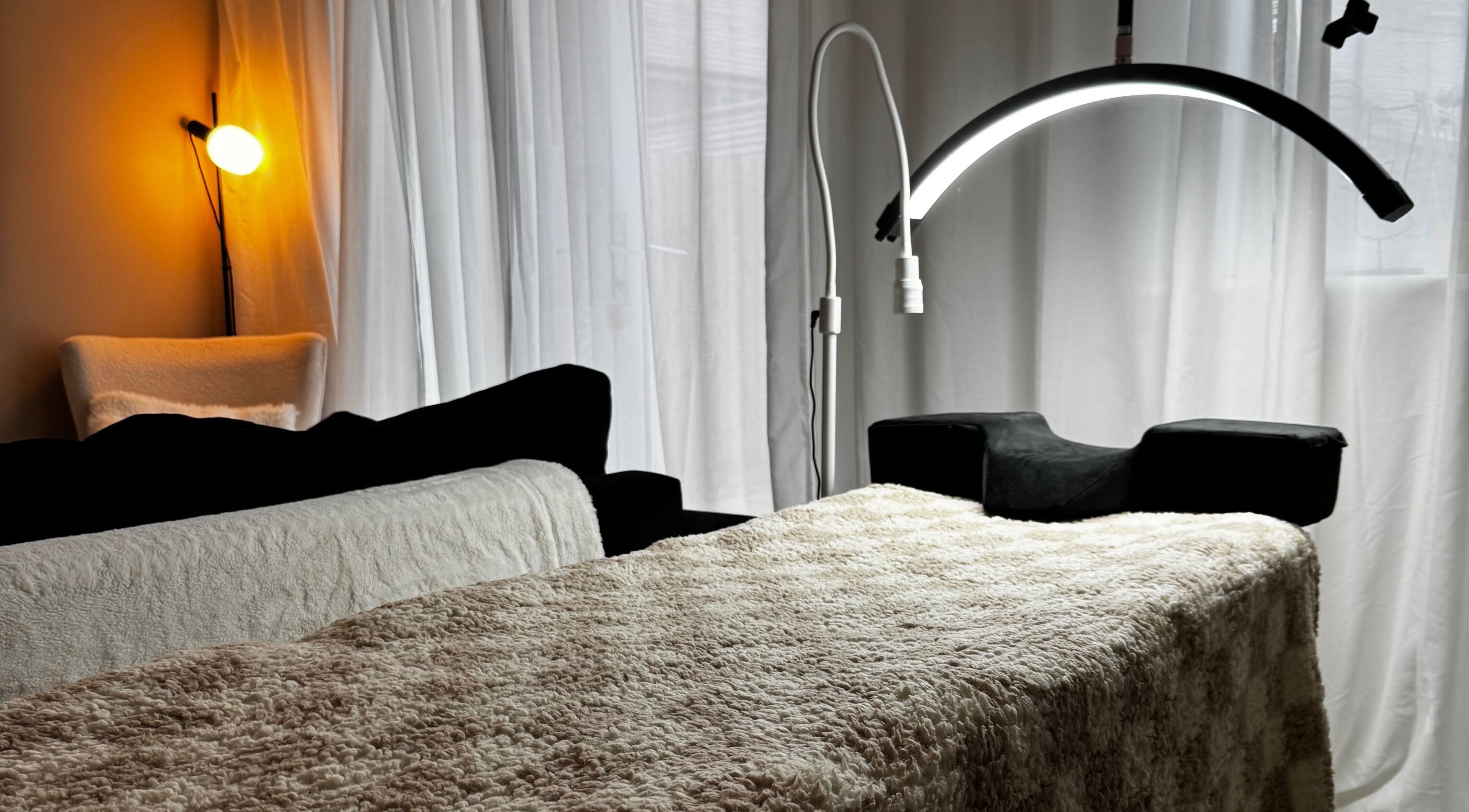 Welcoming treatment room at Lusso Lashes, Brockworth, England, GB with comfortable lighting and decor.