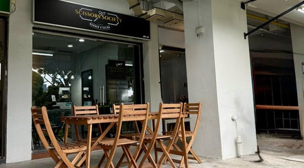 Outdoor view of Scissors Society's modern entrance in Singapore, Singapore, SG with wooden seating.