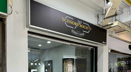 Exterior view of Scissors Society in Singapore, SG, showcasing modern barber salon design.