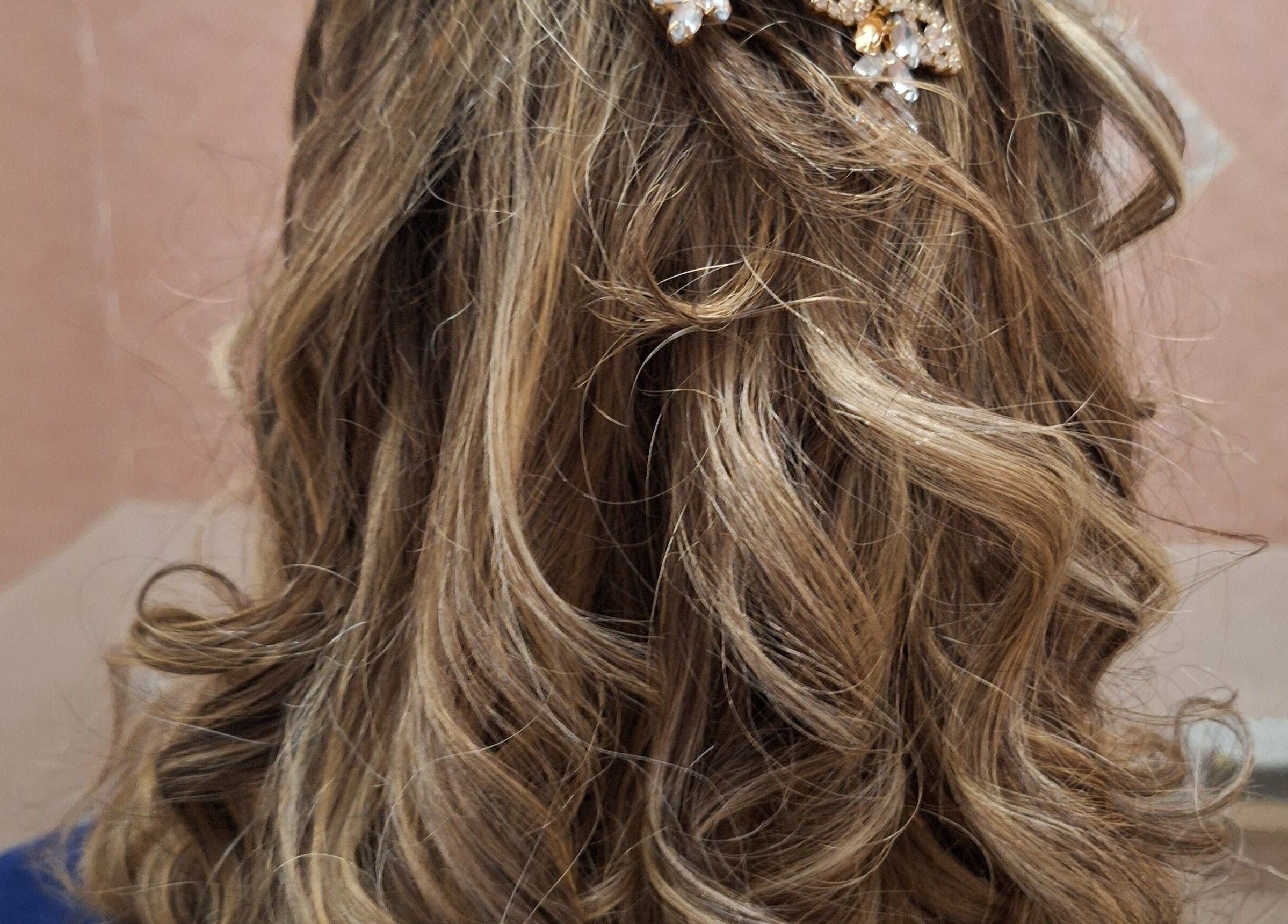 Acconciatura riccia elegante con accessorio floreale presso Nunzia Amoruso, IT.