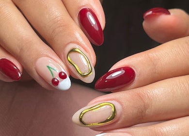 Manicura decorativa en Miradas en ti, Bogotá, Bogotá, CO, mostrando uñas con dibujos de cerezas.