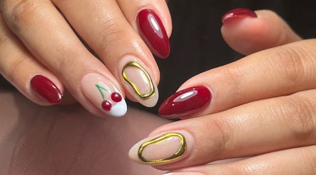 Manicura decorativa en Miradas en ti, Bogotá, Bogotá, CO, mostrando uñas con dibujos de cerezas.