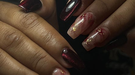 Uñas decoradas con esmalte oscuro y detalles dorados en Miradas en ti, Bogotá, Bogotá, CO.