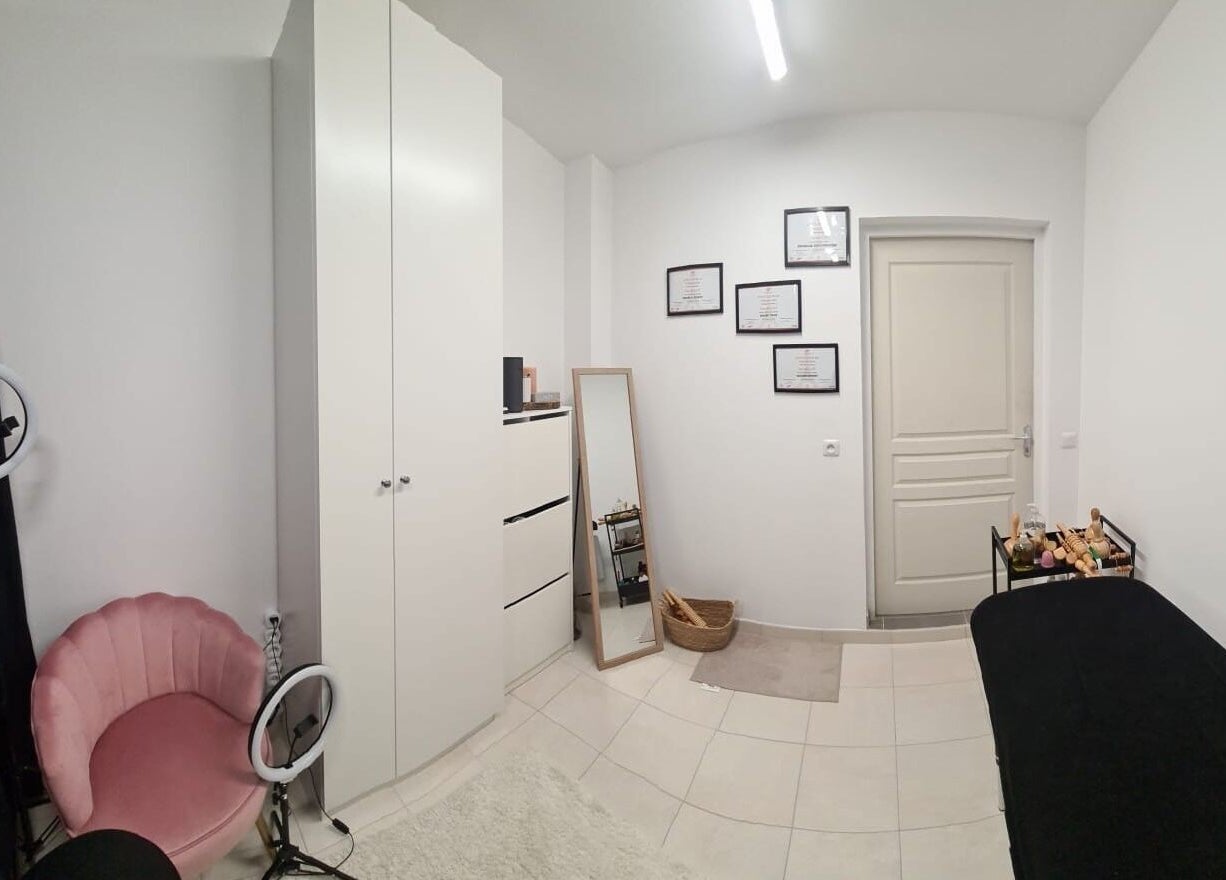 Salle de soins moderne à Maderolympe, Pringy, Île-de-france, FR avec fauteuil rose et miroir.