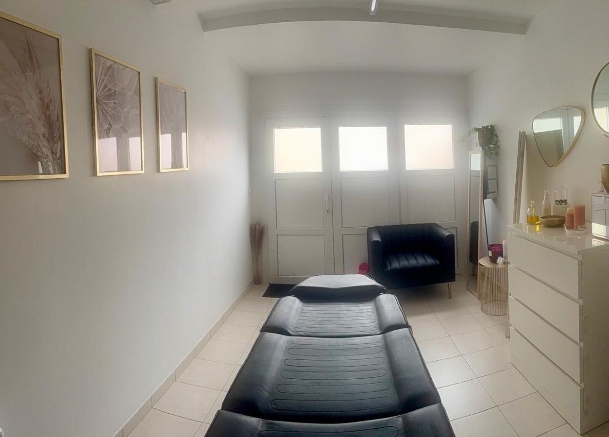 Salle de soin lumineuse chez Maderolympe, Pringy, Île-de-France, FR, avec lit de massage et décor apaisant.