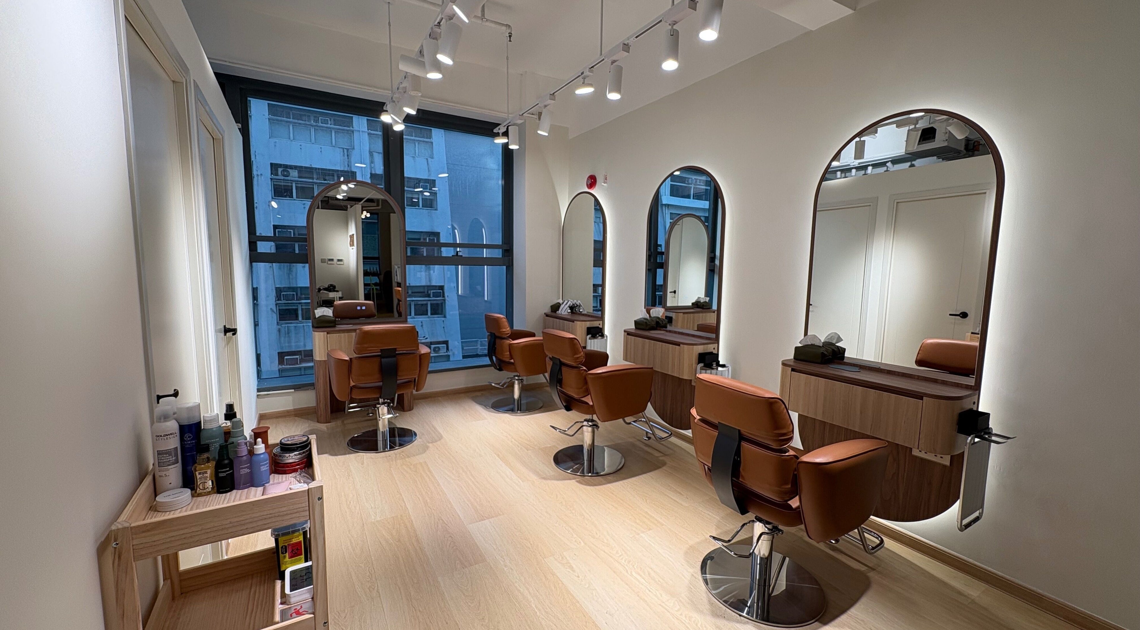Modern interior of Kos Hair Salon on Hong Kong Island, featuring stylish chairs and mirrors.