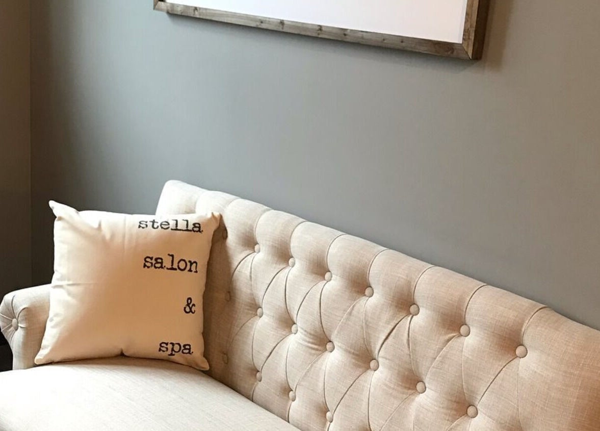 Inviting beige couch at Stella Salon and Spa, Taylor, Pennsylvania, US with branded cushion.
