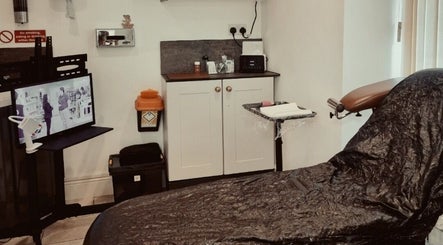 Tattoo studio interior at Sacred Sister Tattoo, Haverfordwest, Wales, GB, with chair and equipment.