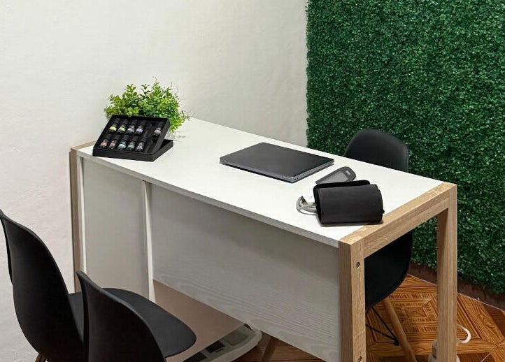 Elegante mesa blanca en Kalize, Oaxaca De Juárez, adornada con plantas y aceites esenciales.