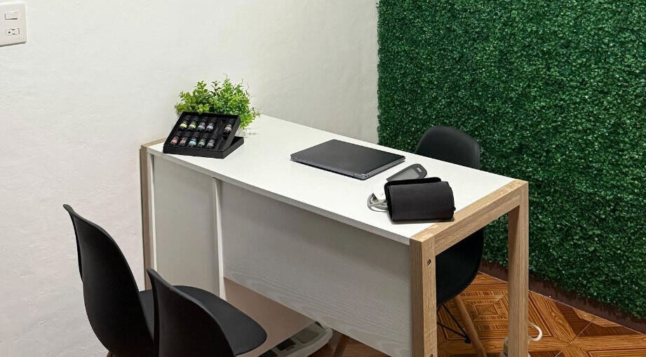 Elegante mesa blanca en Kalize, Oaxaca De Juárez, adornada con plantas y aceites esenciales.