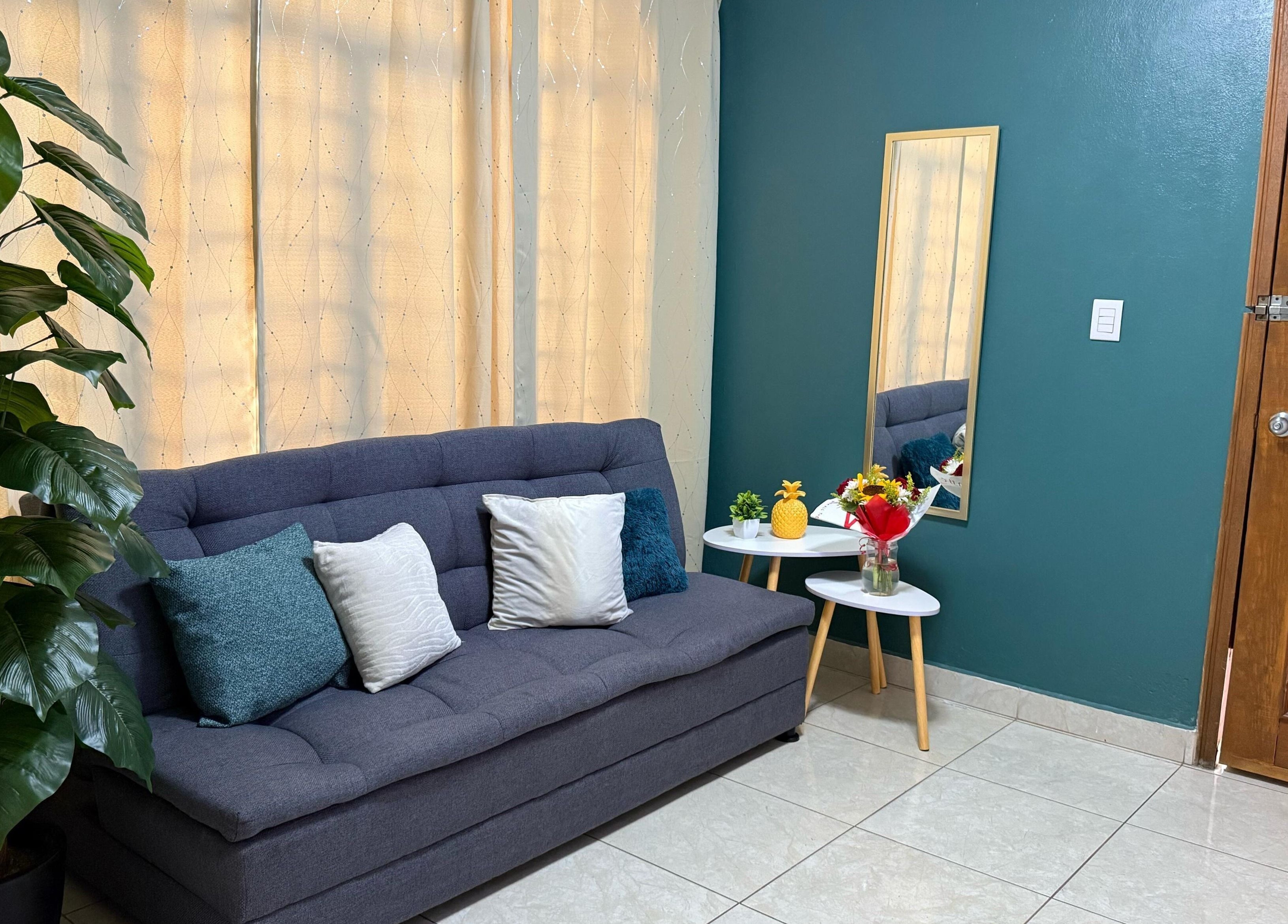 Sala de espera Kalize con sofá gris y espejo, Oaxaca De Juárez, Oaxaca, MX.