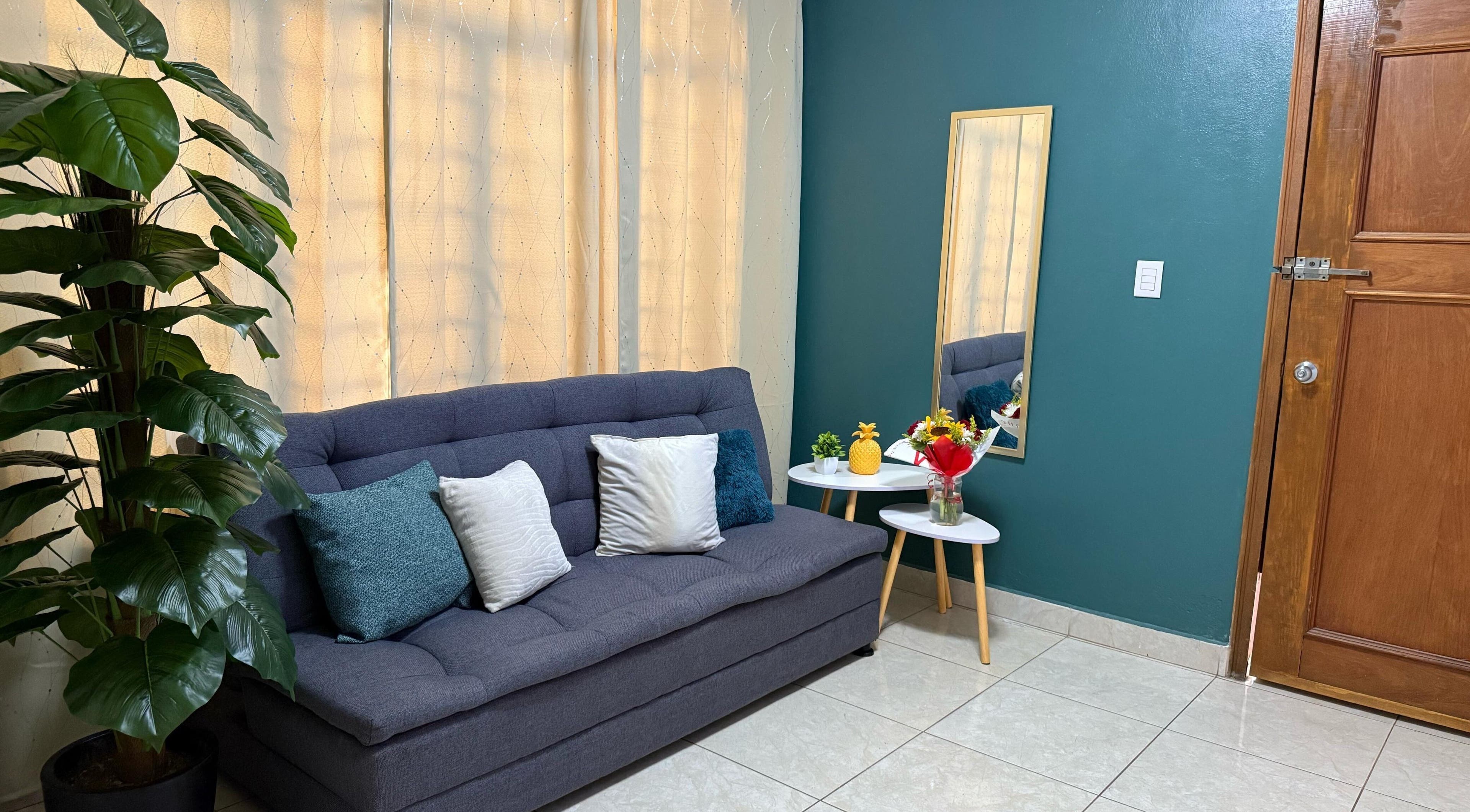 Sala de espera Kalize con sofá gris y espejo, Oaxaca De Juárez, Oaxaca, MX.