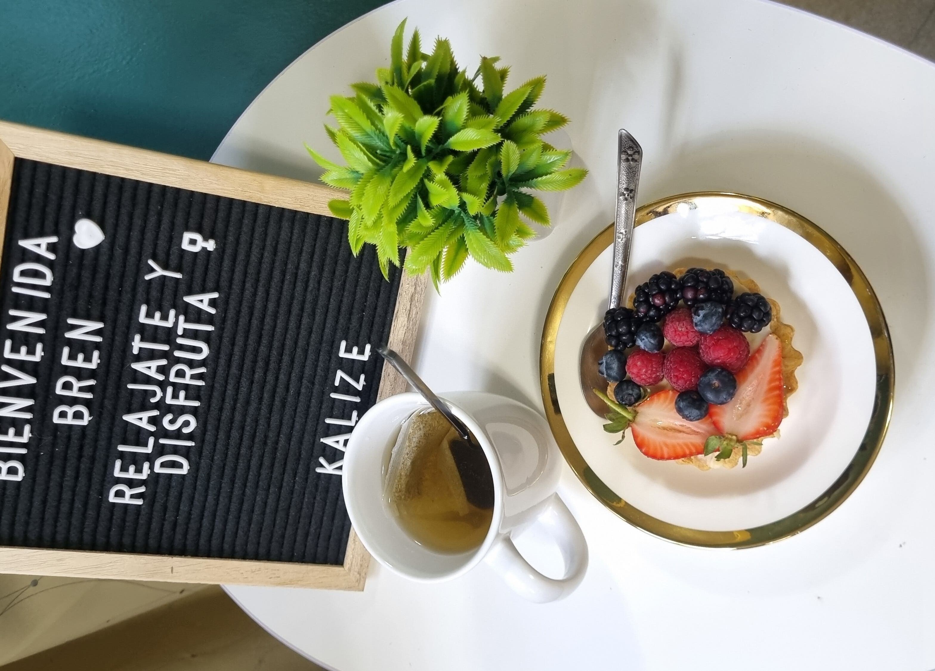 Mesa en Kalize con tarta de frutas, té y letrero de bienvenida. Ubicación: Oaxaca De Juárez, Oaxaca, MX.
