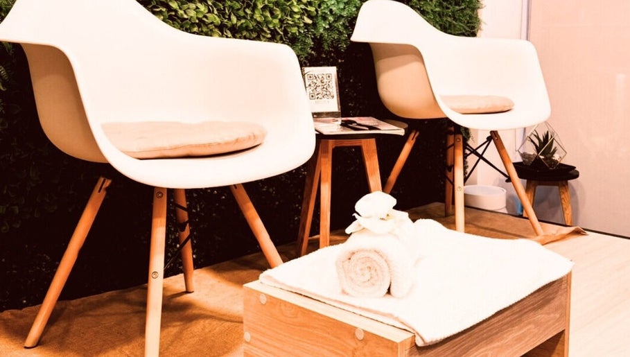Espacio acogedor en Brows By Lili Cázares, Santiago de Querétaro, MX, con sillas modernas y toalla blanca.