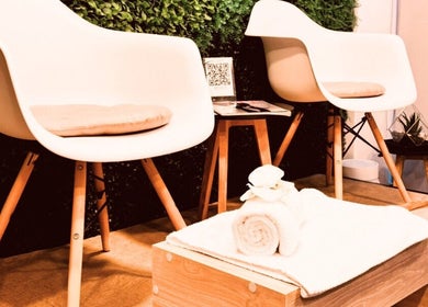 Espacio acogedor en Brows By Lili Cázares, Santiago de Querétaro, MX, con sillas modernas y toalla blanca.