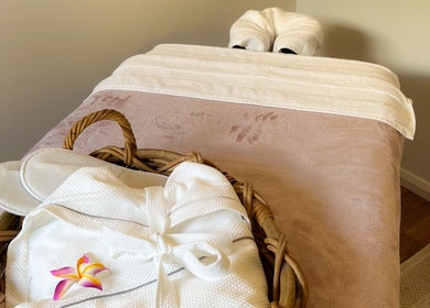 Cozy massage bed at Pure Flow Massage in Bankstown, New South Wales, AU, with robe and slippers.