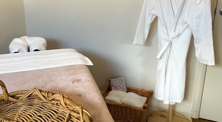 Cozy massage room at Pure Flow Massage in Bankstown, New South Wales, AU with robe and basket.
