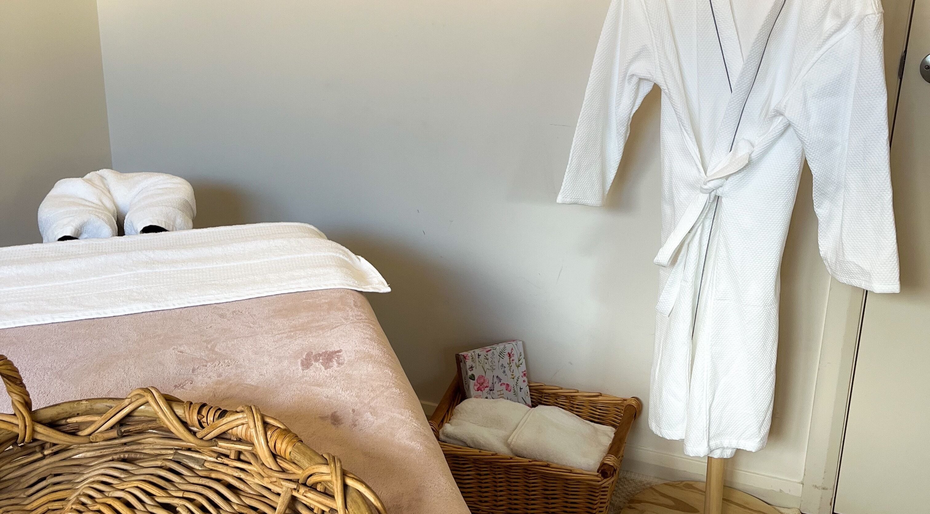 Tranquil massage room at Pure Flow Massage, Bankstown, New South Wales, AU, featuring plush towels and robe.