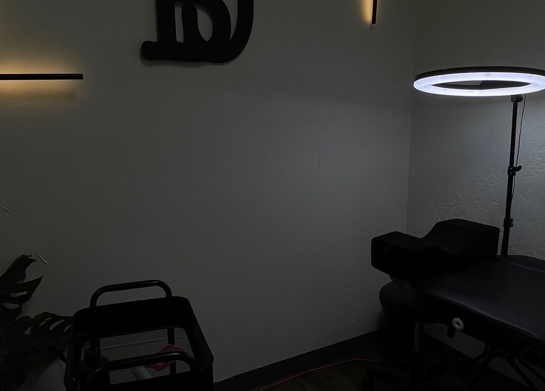 Sala de tratamiento de Danibrows en Phoenix, Arizona, US con iluminación suave y camilla negra.