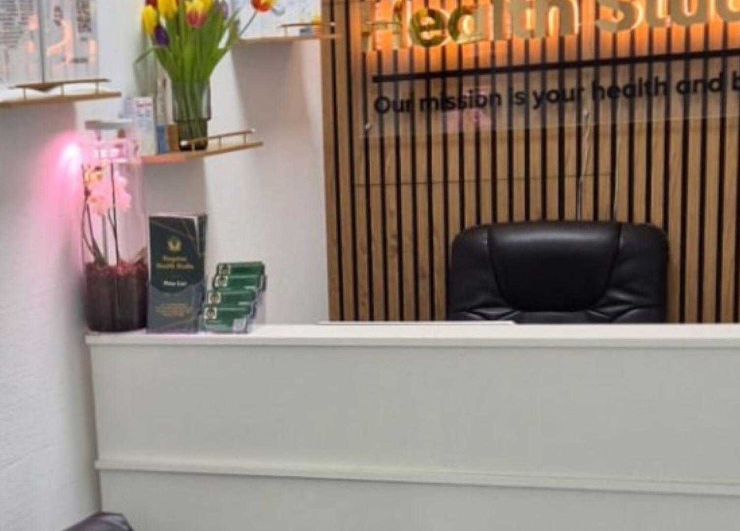 Reception area at Kingston Health Studio, Kingston Upon Thames, England, GB with flowers and seating.