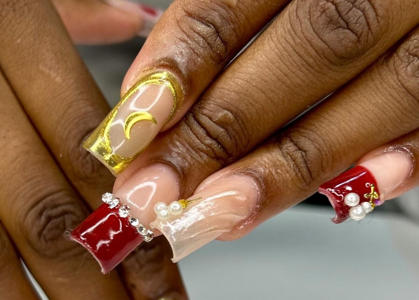 Intricate nail art featuring gold and red designs at The Aphentus in Witpoortjie, Gauteng, ZA.