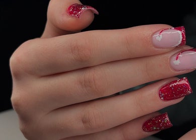 Red glitter nail art at Ellsbeautymark, Aveley, England, GB, showcasing festive manicure style.