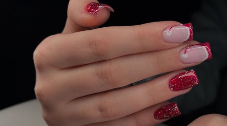 Red glitter nail art at Ellsbeautymark, Aveley, England, GB, showcasing festive manicure style.