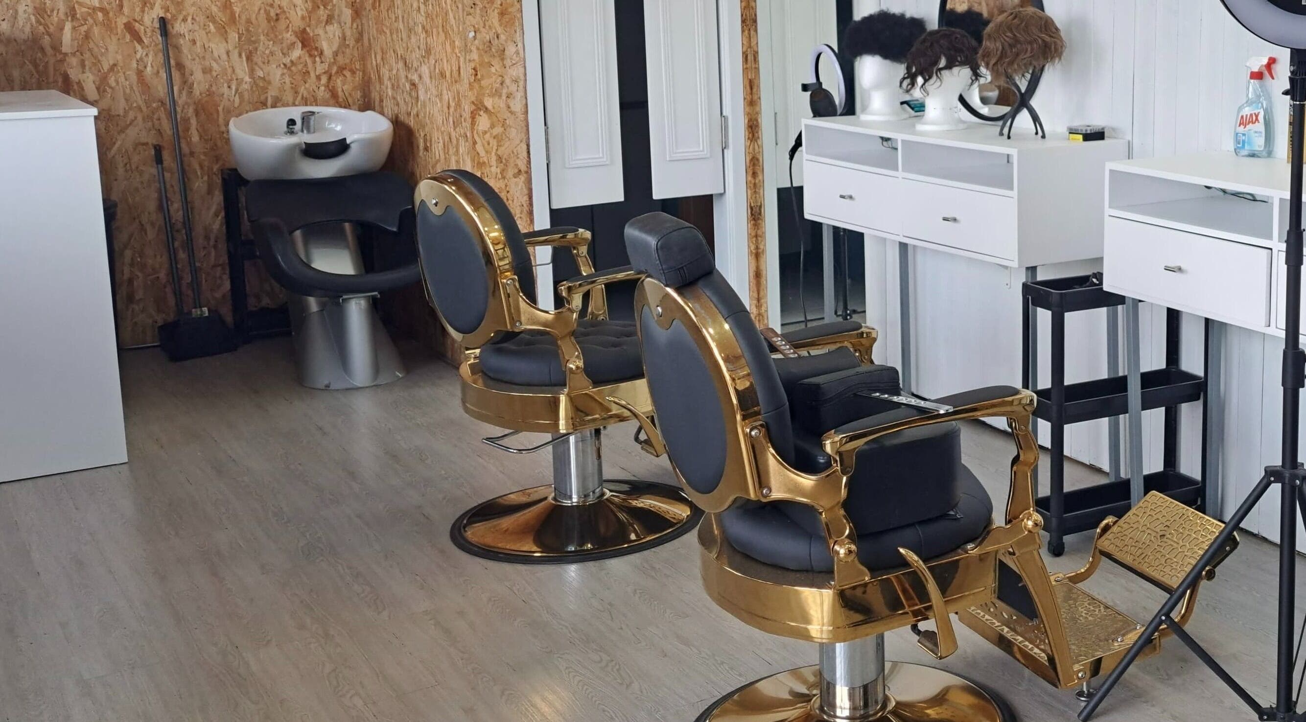 Interior moderno de THE BOSS BARBER em Lisboa, Lisboa, PT com cadeiras douradas luxuosas.