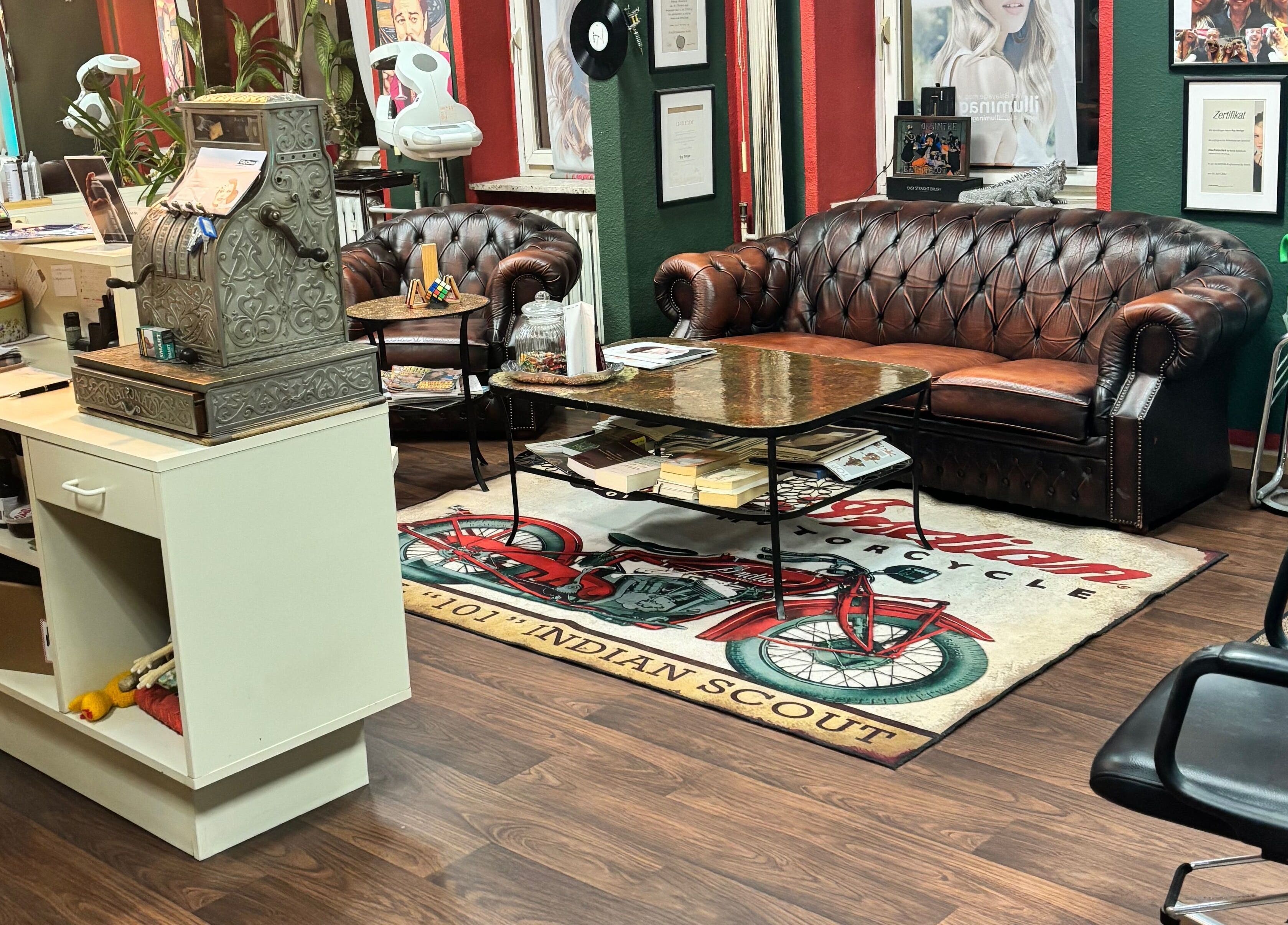 Stilvolle Wartebereich bei Roy's Friseurteam in Berlin, Berlin, DE mit Ledersofa und Vintage-Dekor.