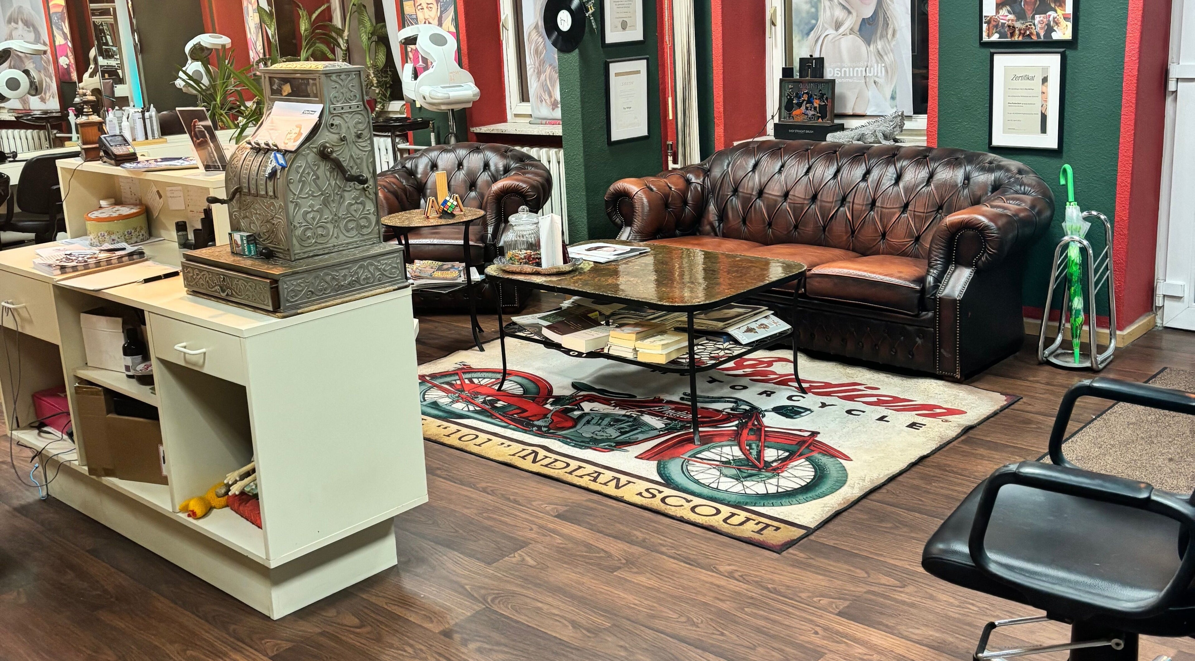 Stilvolle Wartebereich bei Roy's Friseurteam in Berlin, Berlin, DE mit Ledersofa und Vintage-Dekor.