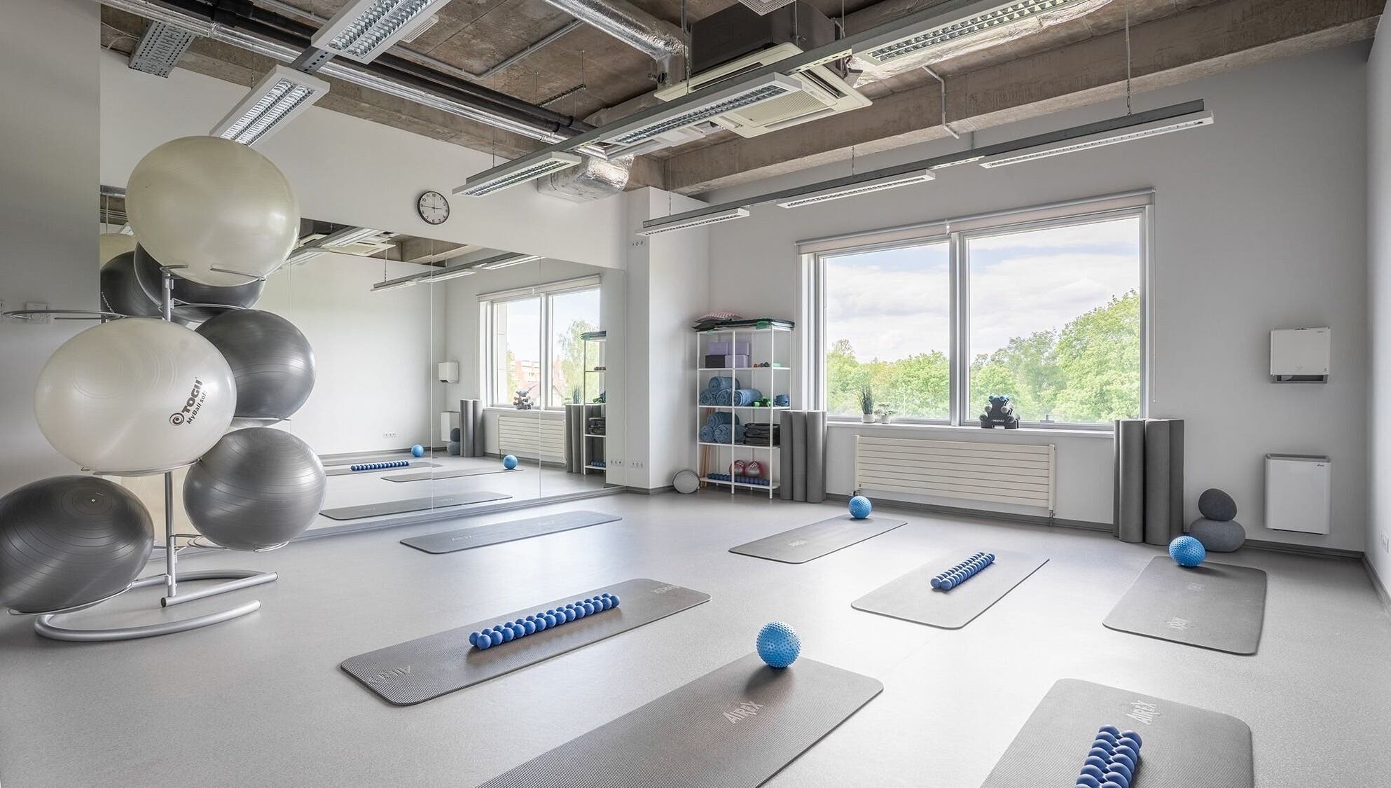 Spacious fitness room at FIZIO LINE, Rīga, LV with mats and exercise balls.