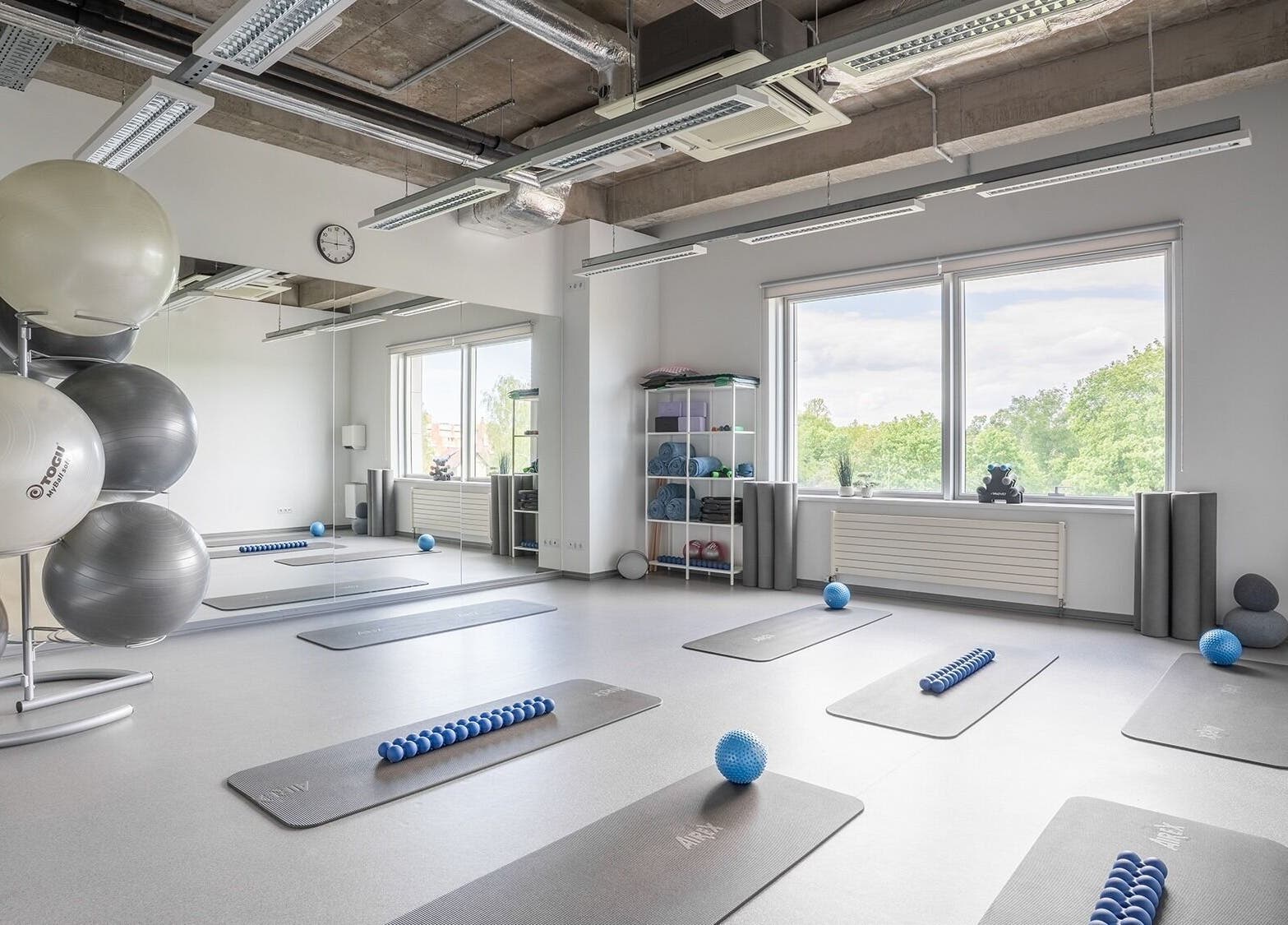Spacious fitness room at FIZIO LINE, Rīga, LV with mats and exercise balls.