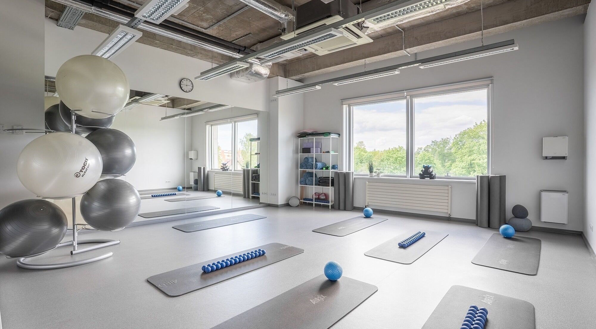 Spacious fitness room at FIZIO LINE, Rīga, LV with mats and exercise balls.