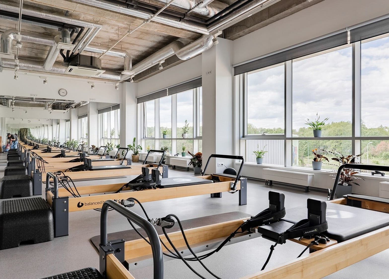 Spacious Pilates studio at FIZIO LINE, Rīga, LV, with bright windows and modern equipment.