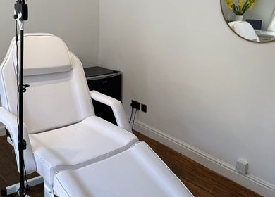 Tranquil treatment room at Rare Aesthetics UK, Brighton And Hove, GB featuring an adjustable white chair.