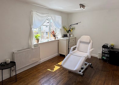 Bright, minimalistic treatment room at Rare Aesthetics UK, Brighton And Hove, GB with comfy white chair.