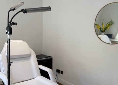 Bright treatment room at Rare Aesthetics UK, Brighton And Hove, GB with modern white chair and minimal decor.