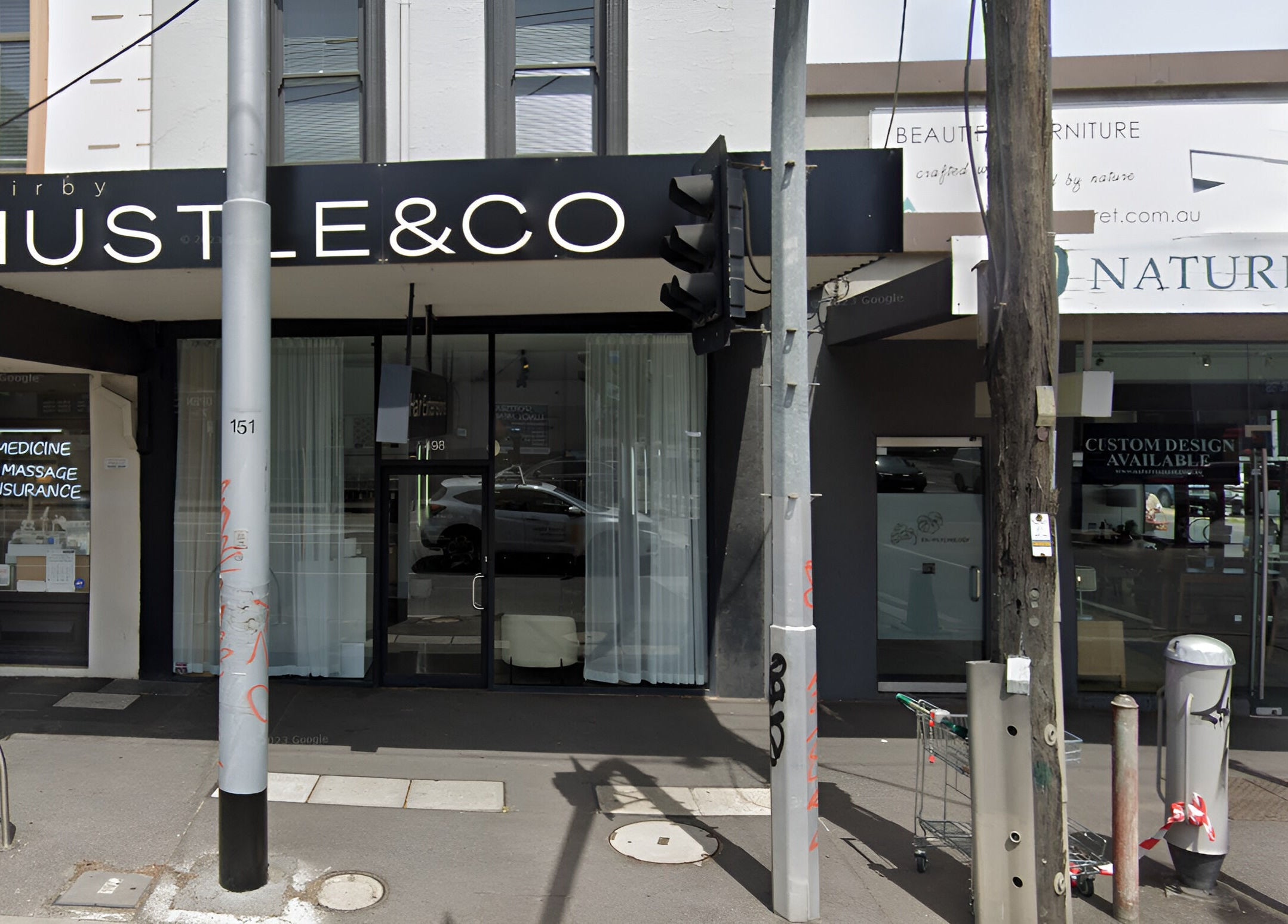 Exterior of Hair by Hustle and Co in Richmond, Victoria, AU, with modern signage and sleek design.