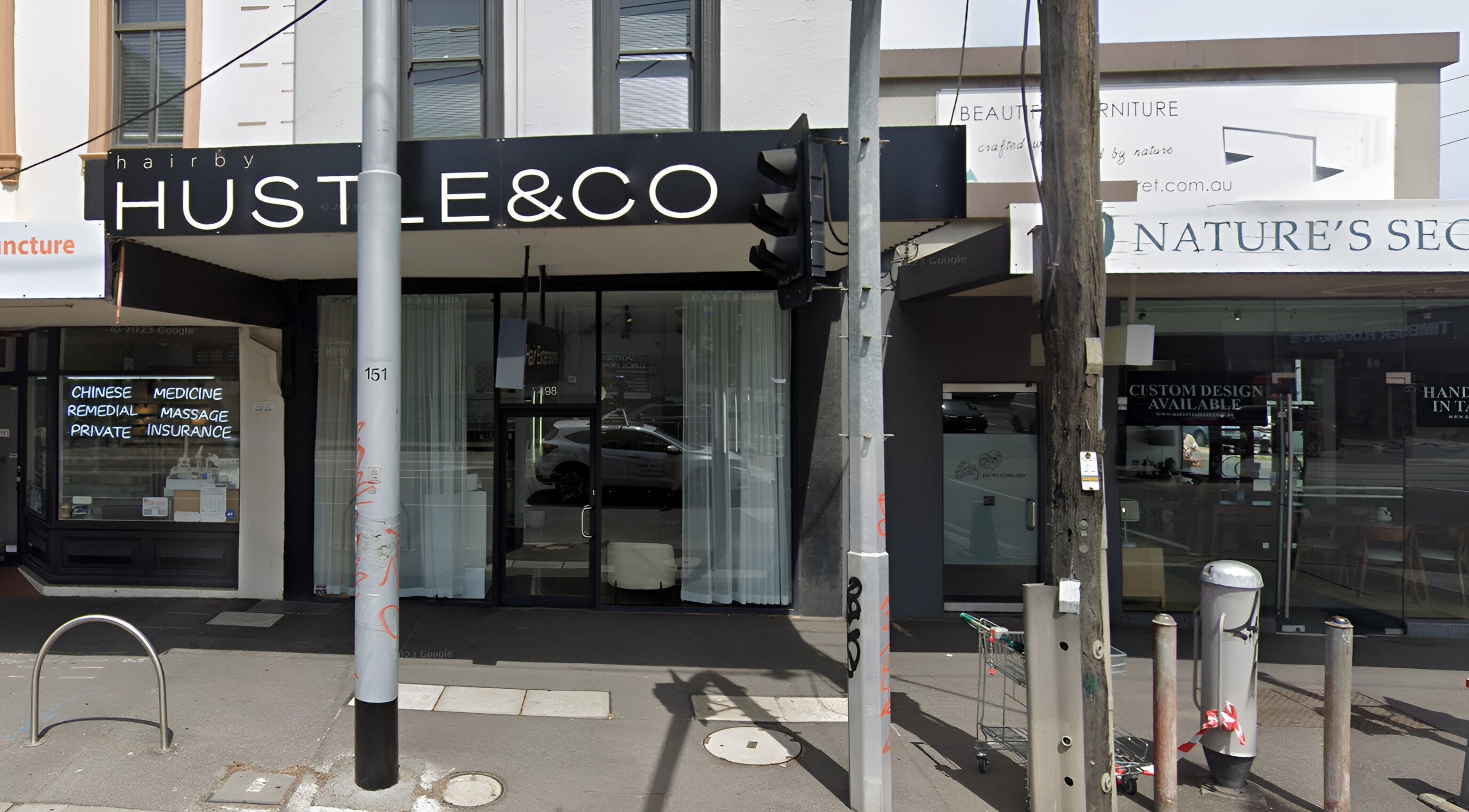 Exterior of Hair by Hustle and Co in Richmond, Victoria, AU, with modern signage and sleek design.