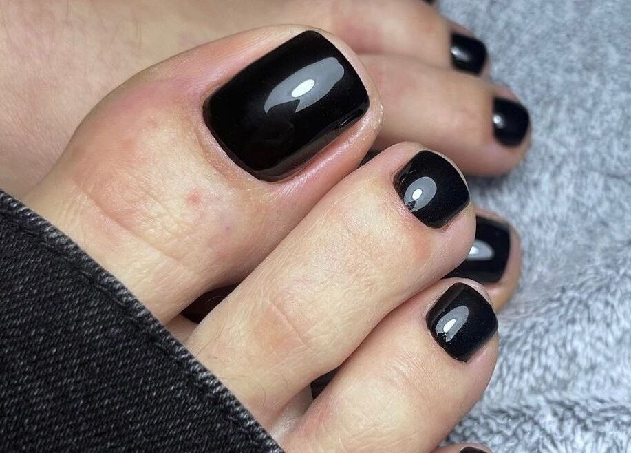Pédicure élégante chez Obranails, Cambrai, Hauts-de-France, FR avec vernis noir brillant.