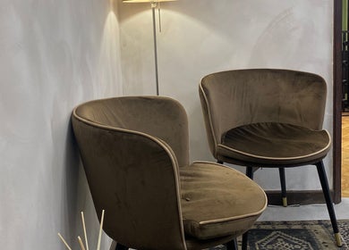 Cadeiras elegantes no salão de espera da Our Porto Studio, Porto, Porto, PT, sob iluminação suave.