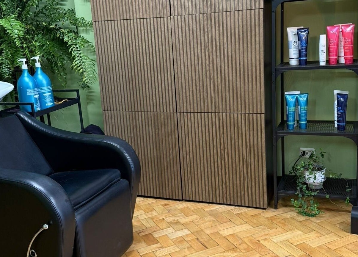 Interior moderno da Our Porto Studio em Porto, Porto, PT com cadeira de salão e produtos de beleza.