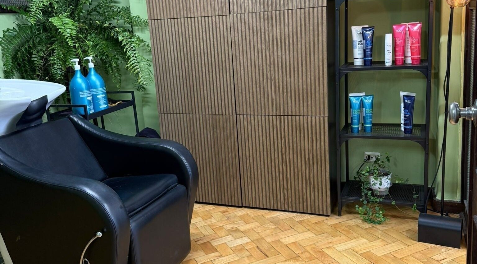 Interior moderno da Our Porto Studio em Porto, Porto, PT com cadeira de salão e produtos de beleza.