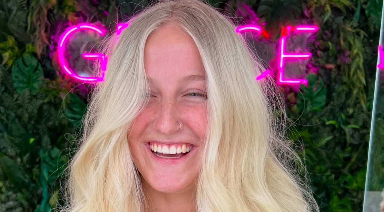 Client with radiant smile at Ella Helmore Hair in Chichester, England, GB, showcasing vibrant blonde hairstyle.