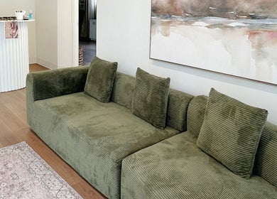 Cozy seating at A.B. SKINCARE STUDIO, Winnipeg, Manitoba, CA, featuring olive green sofa and modern decor.